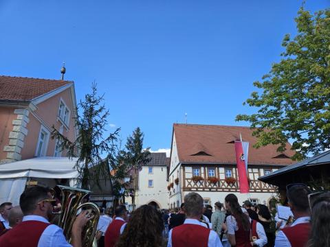 Aufstellung des Kirchweihbaums. Im Hintergrund das Gochsheimer Rathaus, ein Fachwerkbau. Vorne Publikum und Mitglieder der Blaskapelle Mönchstockheim.