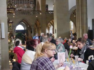 Ein Blick aus dem Chorraum in die St. Johanniskirche: Alle Tische sind besetzt, die Menschen reden miteinander.
